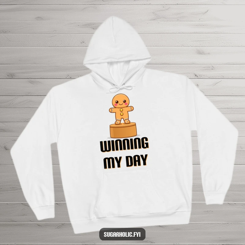 Funny hoodie featuring a proud gingerbread cookie with button eyes on a podium, symbolizing achievement and warmth.